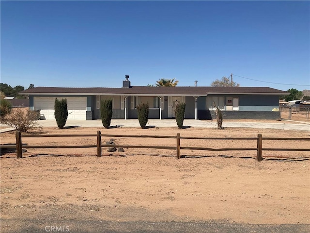 single story home with concrete driveway, a garage, and a fenced front yard