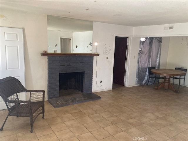 living area with a brick fireplace and visible vents
