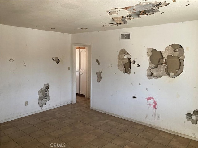 unfurnished room with visible vents