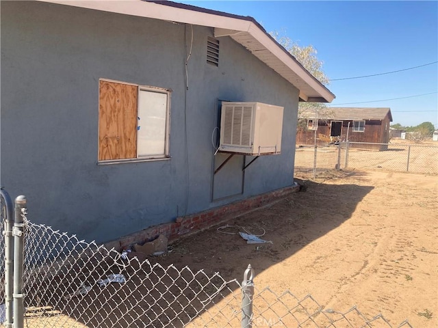 view of side of home featuring stucco siding and fence