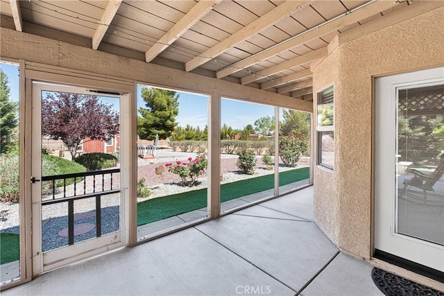 unfurnished sunroom with beamed ceiling