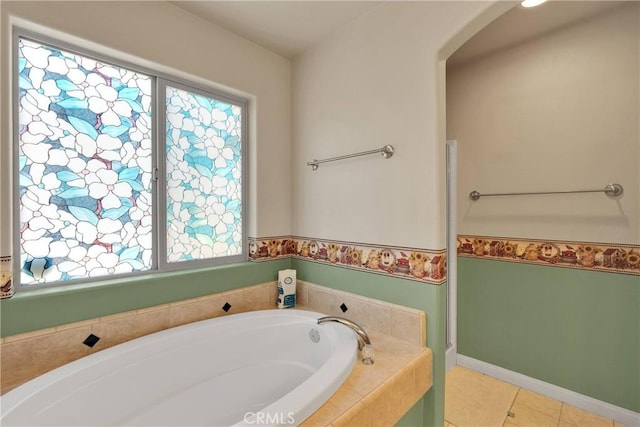 full bathroom with a garden tub, tile patterned floors, and baseboards