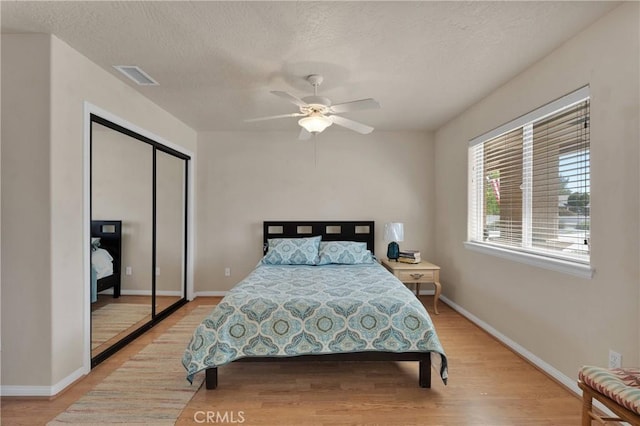 bedroom with light wood finished floors, baseboards, and visible vents