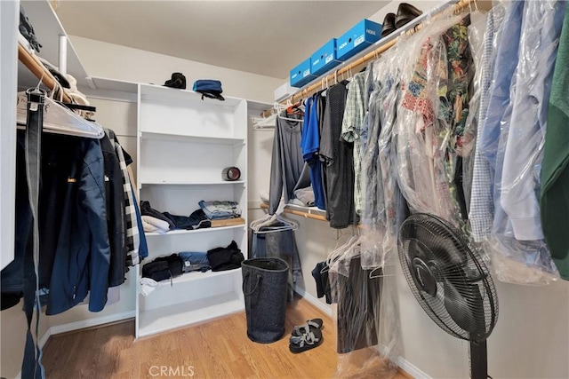 walk in closet with wood finished floors