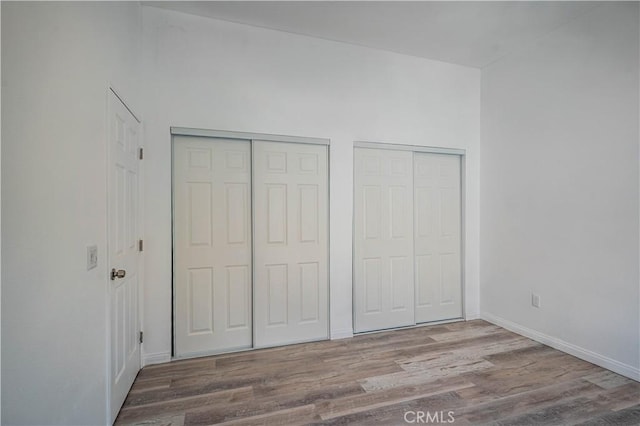 29847 Smugglers Point Dr, Canyon Lake, CA 92587 - unfurnished bedroom featuring two closets and wood finished floors