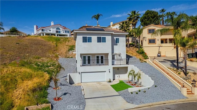 29847 Smugglers Point Dr, Canyon Lake, CA 92587 - view of front of property featuring french doors, a balcony, stucco siding, driveway, and roof mounted solar panels