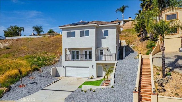 29847 Smugglers Point Dr, Canyon Lake, CA 92587 - view of front of home featuring a balcony, solar panels, stucco siding, french doors, and concrete driveway
