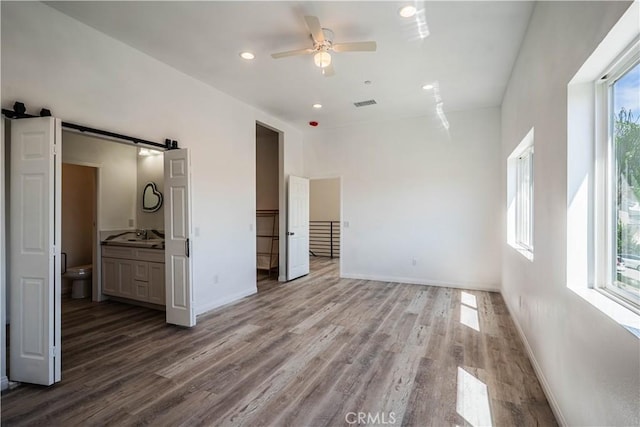 29847 Smugglers Point Dr, Canyon Lake, CA 92587 - unfurnished bedroom with multiple windows, a barn door, wood finished floors, and recessed lighting