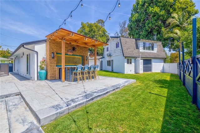 rear view of property featuring a fenced backyard, outdoor dry bar, a yard, a patio, and stucco siding
