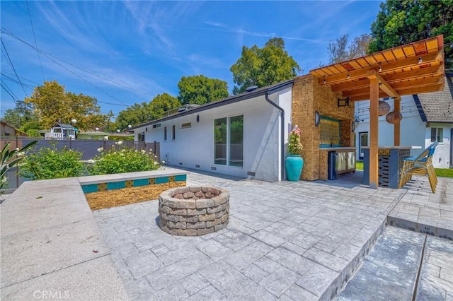 back of property featuring outdoor dry bar, a patio area, and an outdoor fire pit