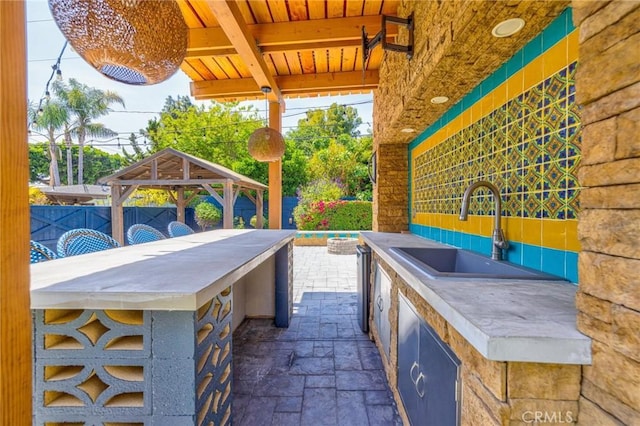 view of patio / terrace with a sink, a gazebo, outdoor wet bar, fence, and area for grilling