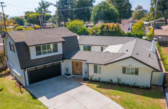 view of front of property with a garage, roof with shingles, board and batten siding, and concrete driveway