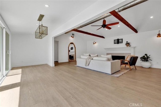 living room featuring light wood-style flooring, vaulted ceiling with beams, baseboards, a ceiling fan, and a fireplace