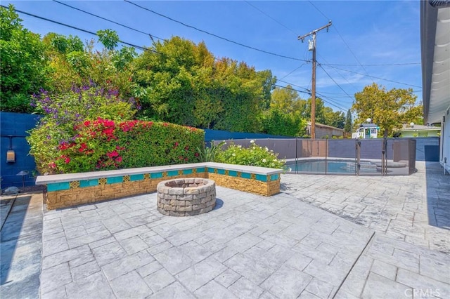 view of patio featuring a fire pit, a fenced in pool, and a fenced backyard