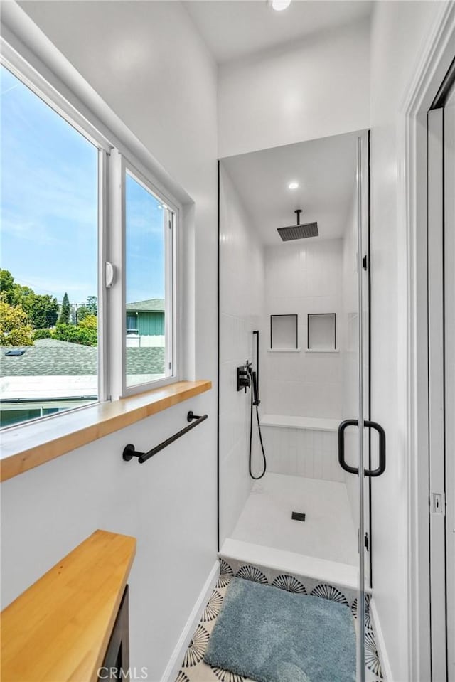 bathroom with recessed lighting, baseboards, and tiled shower