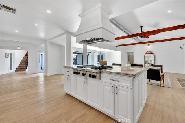 kitchen with stainless steel gas cooktop, open floor plan, visible vents, and light wood finished floors