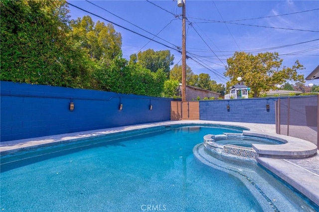 view of pool with a pool with connected hot tub and a fenced backyard