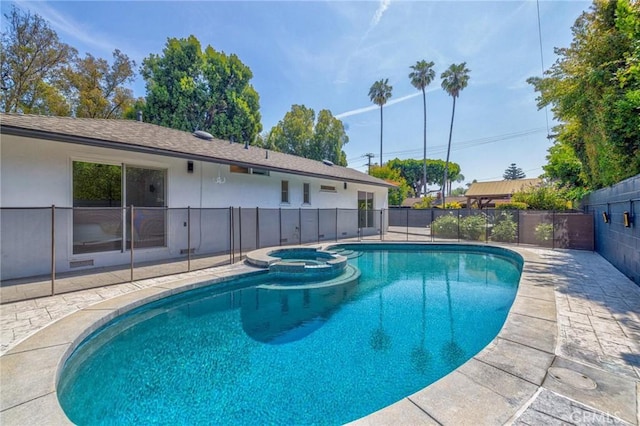 view of swimming pool with fence, a patio area, and a pool with connected hot tub