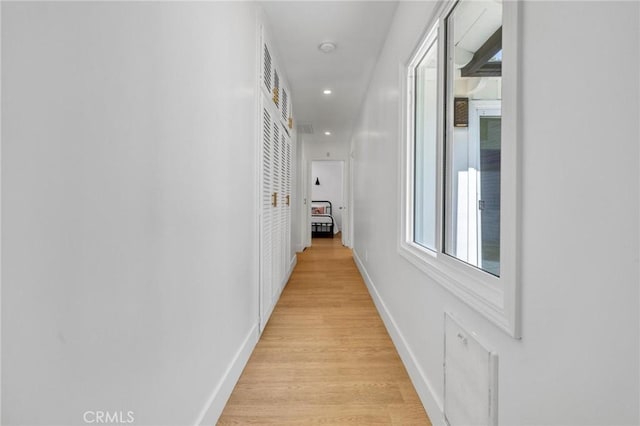hallway featuring light wood-type flooring, baseboards, and recessed lighting