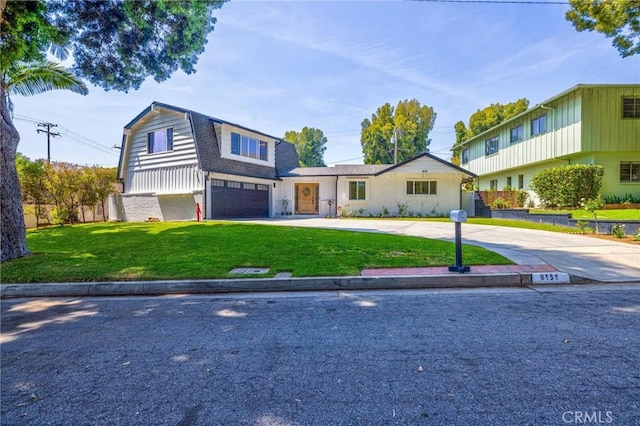 view of front of property with an attached garage, a gambrel roof, driveway, and a front yard