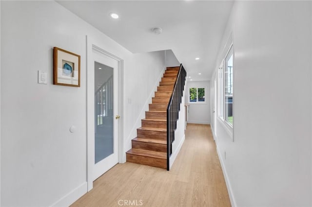 staircase with baseboards, wood finished floors, and recessed lighting