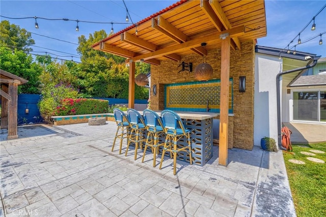 view of patio / terrace with outdoor dry bar and fence