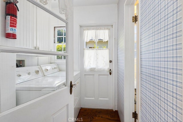 laundry room featuring cabinet space, wallpapered walls, and washer and dryer