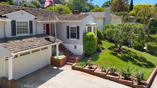 ranch-style home featuring driveway, a chimney, a garage, stairs, and a front yard