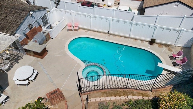view of swimming pool with a fenced backyard, a patio area, and a pool with connected hot tub