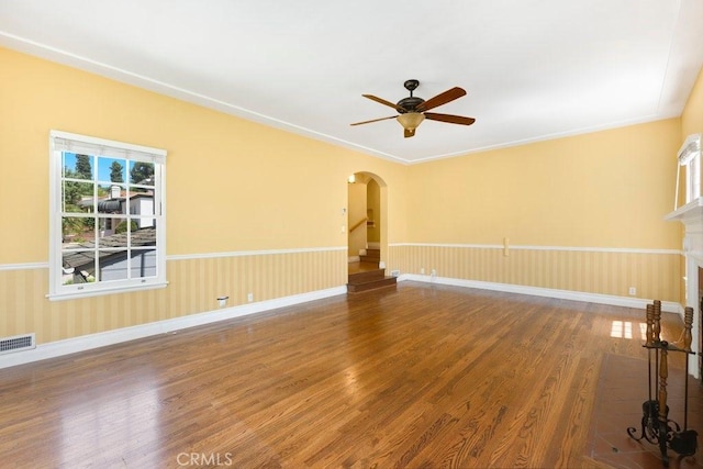spare room featuring visible vents, a ceiling fan, wood finished floors, and arched walkways
