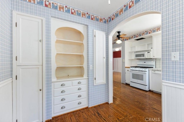 kitchen with dark wood-style floors, wallpapered walls, a ceiling fan, white appliances, and open shelves