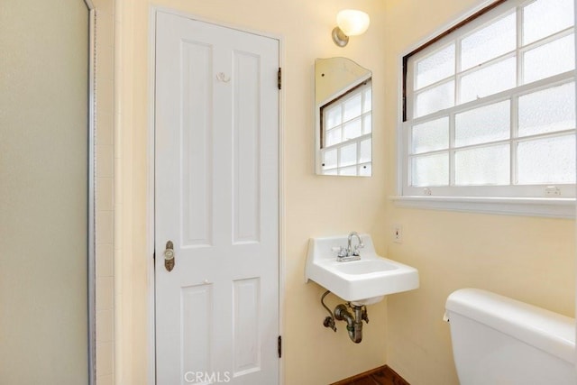 full bath featuring toilet and a sink