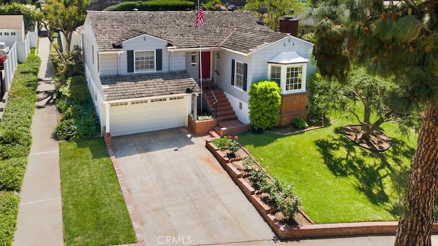 view of front of house featuring a chimney, fence, a front lawn, concrete driveway, and an attached garage