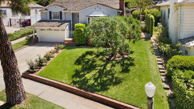 view of front of house with concrete driveway, a front lawn, and a garage