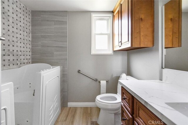 114 Via Estrada Unit B, Laguna Woods, CA 92637 - full bathroom with toilet, wood finished floors, vanity, a whirlpool tub, and baseboards