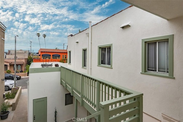 view of side of home featuring a balcony and stucco siding