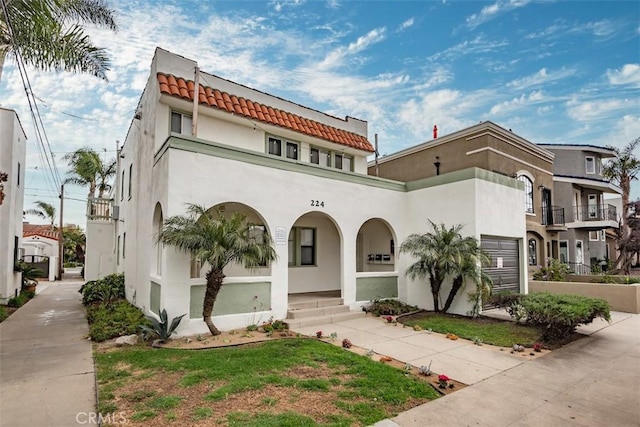 view of front of property featuring a porch, a tiled roof, and stucco siding