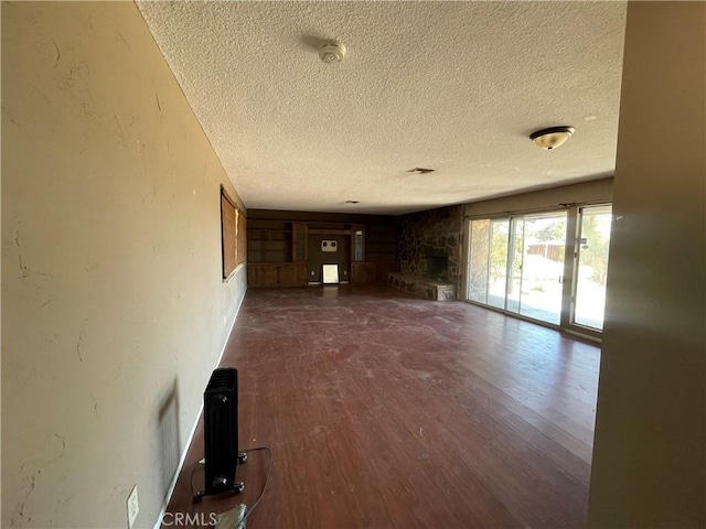 unfurnished living room featuring dark wood-style flooring, a textured ceiling, and a fireplace