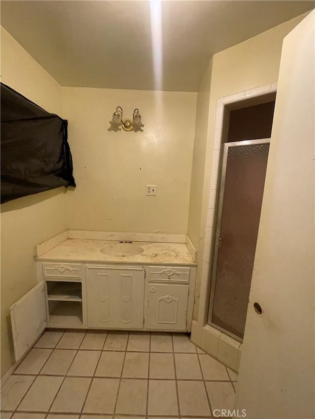 full bath featuring tile patterned floors, vanity, and a shower stall