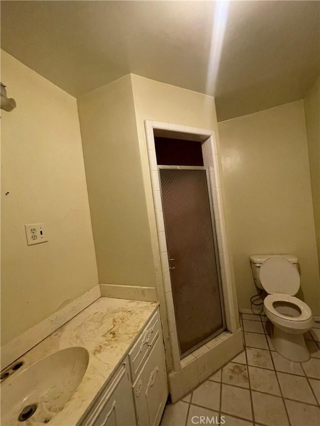 full bath with toilet, vanity, tile patterned flooring, and a stall shower