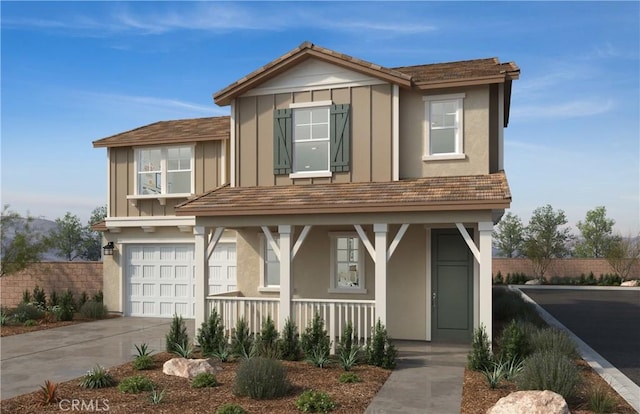 traditional-style house featuring stucco siding, an attached garage, driveway, and covered porch