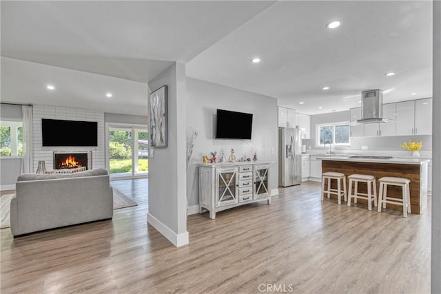 7293 Cirrus Way, West Hills, CA 91307 - living room featuring baseboards, light wood-style flooring, recessed lighting, and a brick fireplace