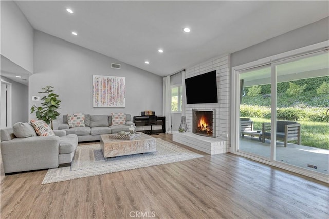 7293 Cirrus Way, West Hills, CA 91307 - living area featuring wood finished floors, recessed lighting, a brick fireplace, and high vaulted ceiling