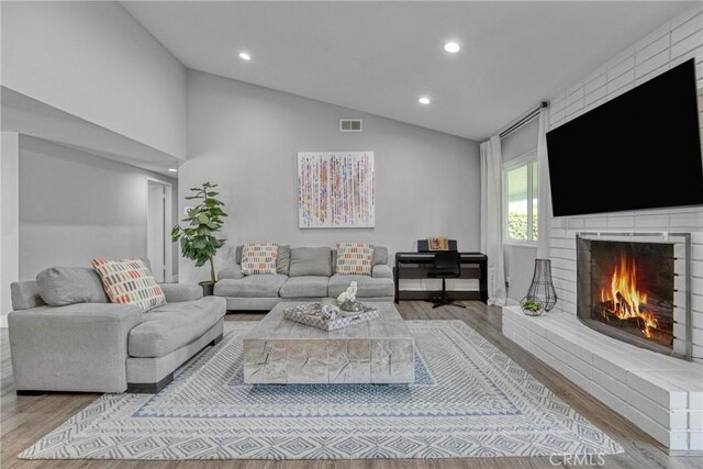 7293 Cirrus Way, West Hills, CA 91307 - living area featuring wood finished floors, vaulted ceiling, a fireplace, and recessed lighting