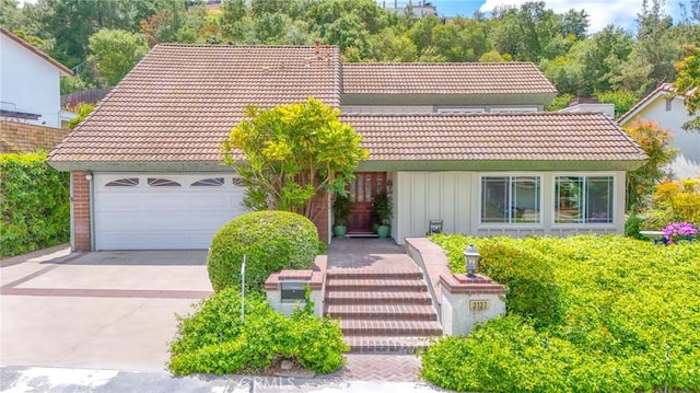 3137 Cabo Blanco Dr, Hacienda Heights, CA 91745 - view of front facade with an attached garage, board and batten siding, concrete driveway, and a tile roof