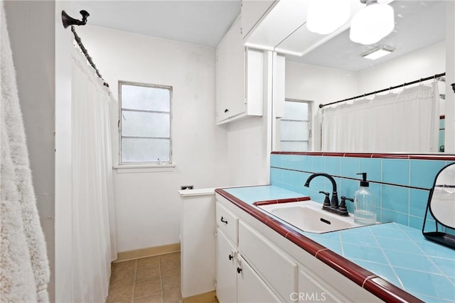 full bath featuring vanity, baseboards, tile patterned floors, a shower with curtain, and backsplash