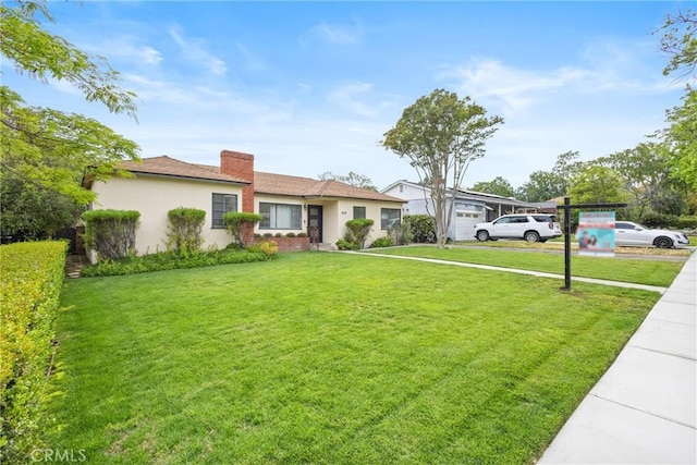 ranch-style home featuring stucco siding, a chimney, and a front lawn