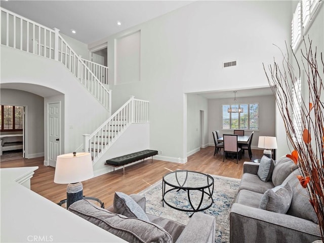 25626 Moore Ln, Stevenson Ranch, CA 91381 - living room with a towering ceiling, arched walkways, wood finished floors, stairs, and baseboards