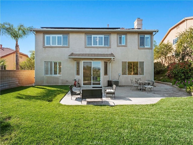 25626 Moore Ln, Stevenson Ranch, CA 91381 - back of property with stucco siding, a chimney, a patio, and solar panels
