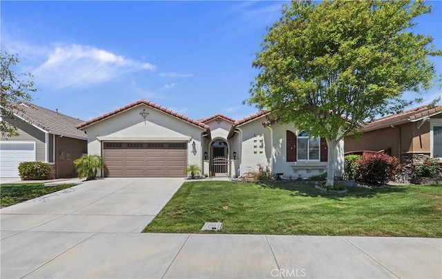 mediterranean / spanish-style home featuring a tiled roof, a front lawn, concrete driveway, an attached garage, and stucco siding